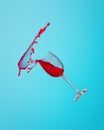 Abstract splash of red wine in a glass on a blue background close up Royalty Free Stock Photo