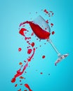 Abstract splash of red wine in a glass on a blue background close up Royalty Free Stock Photo