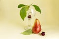 Abstract still life with wineglass, ripe cherries and pears on a light yellow background Royalty Free Stock Photo