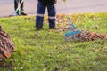 Abstract street cleaner sweeping fallen leaves with rake, autumn day. Fall, leaf fall, city cleaning