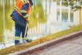 Abstract street cleaner sweeping fallen leaves with rake, autumn day, job in city outdoors Royalty Free Stock Photo