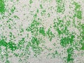 Abstract surface as green paint peeling off a concrete wall background. Old grungy, weathered painted construction structure.