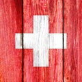 Grunge pattern of Switzerland national flag isolated on weathered wooden fence board.