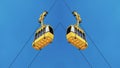 Abstract Symmetrical Image with Two Yellow Cable Cars in the Blue Sky Background. Design Banner Backdrop. Travel Conception