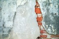 Abstract texture and background of broken plastered cement wall with red bricklayers inside