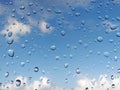 Abstract texture of drops of rain on a window glass. Clean background view of water drops on glass over a blue sky. Rain water Royalty Free Stock Photo