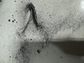 Abstract texture of fine black dust or powder scattered and smeared on a light surface Royalty Free Stock Photo