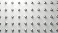 Abstract texture of repeating small metal studs on clean white surface. Uniform grid pattern of circular studs create minimalist Royalty Free Stock Photo