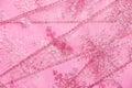 Abstract textured background of pink net ribbon with glitter snowflakes Royalty Free Stock Photo