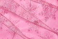 Abstract textured background of pink net ribbon with glitter snowflakes Royalty Free Stock Photo