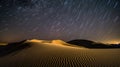 Abstract time lapse night sky with shooting stars over desert dune landscape. Milky way glowing lights background. Royalty Free Stock Photo