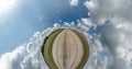 Abstract torsion and spinning of full flyby panorama among green grass fields in sunny evening with awesome clouds