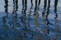 Abstract:Trails of Wooden Pier Reflections on Blue Water Royalty Free Stock Photo