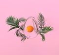 Abstract transparent easter egg composition with palm leaves on pink background. 3d illustration. Royalty Free Stock Photo