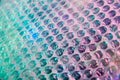 Holographic background in the style of the 80-90s. Real texture of bubble wrap film in bright acid colors.