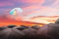 abstract umbrella flying over many black umbrellas with beautiful sky, leadership background concept.