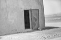 Abstract unreal picture of the corner of a house in the desert with an open blue damaged door of iron, Sudan Royalty Free Stock Photo