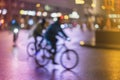 Abstract unrecognizable people, riding bikes, night city, illumination bokeh, motion blur. Healthy lifestyle, leisure Royalty Free Stock Photo