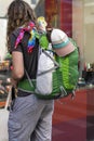 Unrecognizable tourist with a backpack standing near the showcase of shop souvenirs, travel and tourism concept