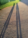 abstract very long shadows of two people on the ground Royalty Free Stock Photo