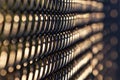 Abstract view of black chain link fence in evening sunlight