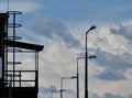 Clouds and blue sky on spring day with steel platform and street lamps