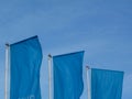 Light blue flags under blue sky on aluminum poles Royalty Free Stock Photo