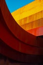 Abstract view of modern sculptural architecture with vibrant red and yellow curves.