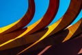 Abstract view of modern sculptural architecture with vibrant red and yellow curves.