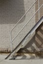 Abstract view of an old gray fire escape staircase in front of a vintage brick wall Royalty Free Stock Photo