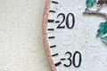 Abstract view of part of a large Garden thermometer showing minus degree values on its round design.