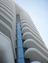 Abstract view on residential apartment complex building with many balconies and floors isolated against blue sky on sunny day Royalty Free Stock Photo