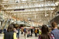 Abstract view of Waterloo Station with many passengers in a rush and a clock in London, England