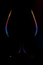 Abstract view on a wine glass silhouette with lighted multi-colored gradient edges on a black background Royalty Free Stock Photo