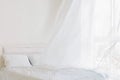 Abstract waving curtains in white bedroom with white bed Royalty Free Stock Photo