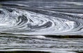 Abstract white foam swirls on dark water