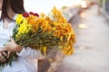 Abstract woman with bouquet flowers vibrant in hands on blur street