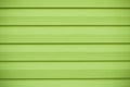 Abstract wood plank background. Green wooden texture in horizontal stripes. Board of lime color, yellow wall in lines, bright surf