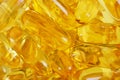 Abstract yellow background from many fish oil capsules. Background or backdrop of softgels. Healthy lifestyle. Softgel closeup.