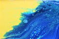 Abstract yellow-blue marble background. The lines and waves of acrylic paint create an interesting structure. Royalty Free Stock Photo