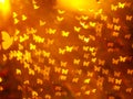 abstract yellow butterfly shape bokeh on golden red blurred light background. Royalty Free Stock Photo