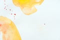 Abstract yellow watercolor strokes with red splatters
