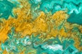 Abstract yellow waves on green background with golden inclusions. Free flowing paint. Acrylic fluid art Royalty Free Stock Photo