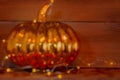 Abstracted glass pumpkin is wrapped in lights and glows