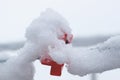 Lying thick layer of snow on a red object and wire. Close up. Mimimalism