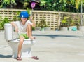 Absurd picture: cute boy in goggles sitting on the toilet, which Royalty Free Stock Photo