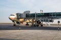 Abu Dhabi . November 2012. Airplane is on the platform at the glass jet bridge at the Abu Dhabi airport. Preparation for flight Royalty Free Stock Photo