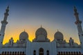 The Sheikh Zayed Grand Mosque symmetrical exterior in Abu Dhabi during golden sunset