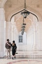 Young couple walk through arched entrance group with snow white marble columns in Presidential Palace Qasr Al Watan,new UAE landma