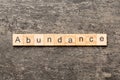 abundance word written on wood block. abundance text on table, concept